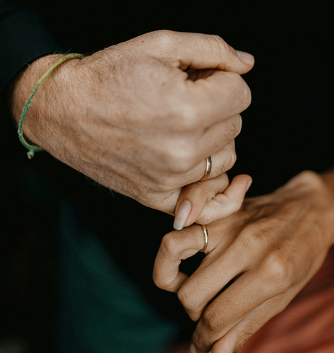 Two adults’ hands gently clasped together.